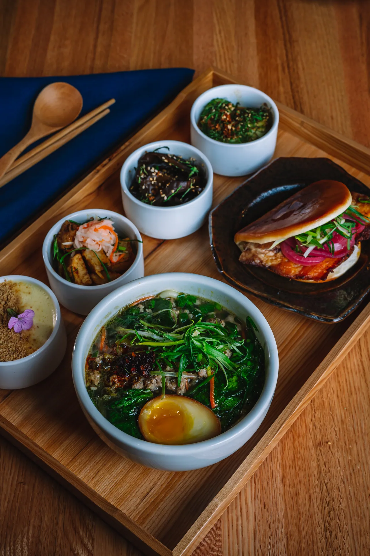 Noodle bowl, buns and small side dishes arranged together