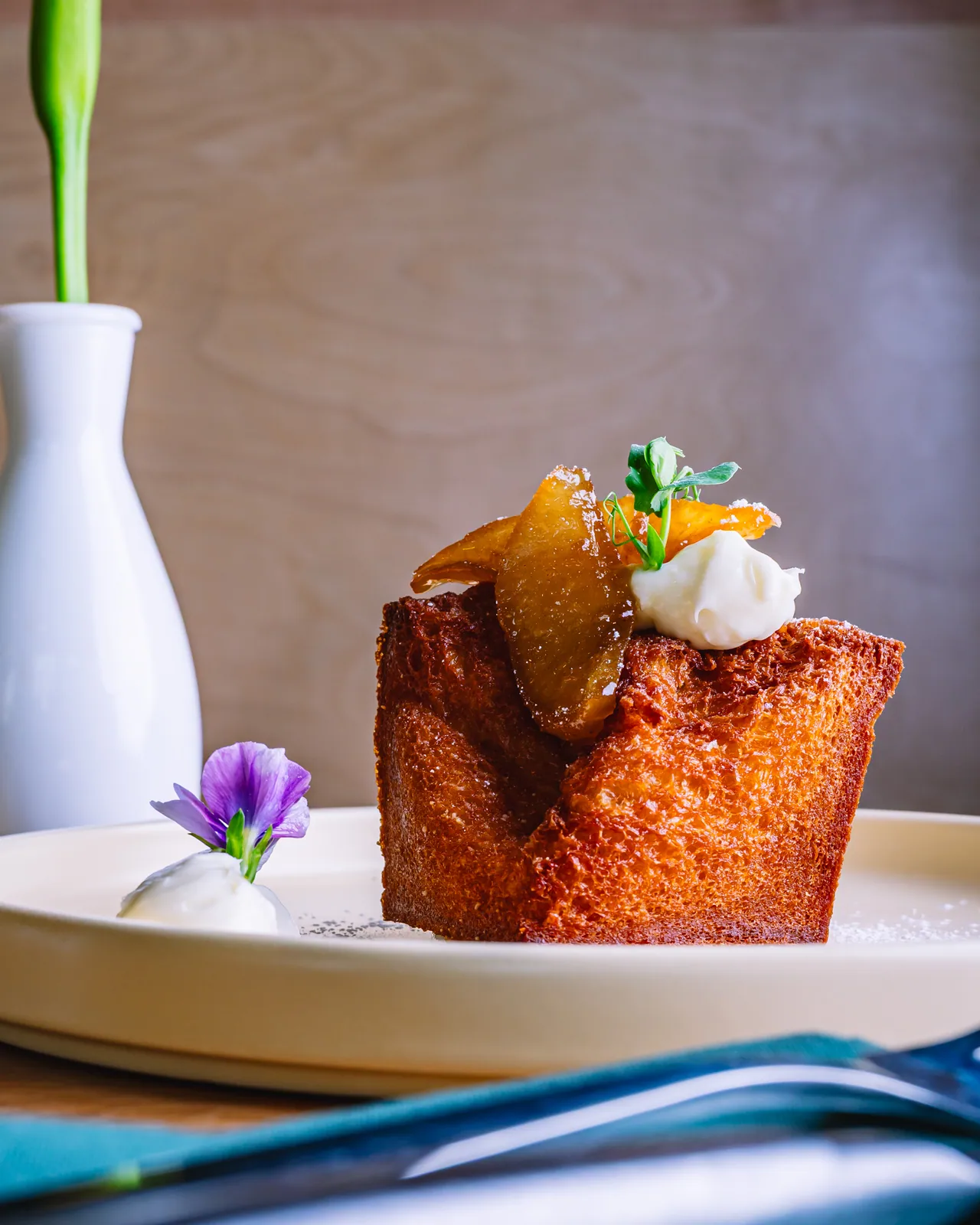A tall golden toast topped with a white scoop and strawberry