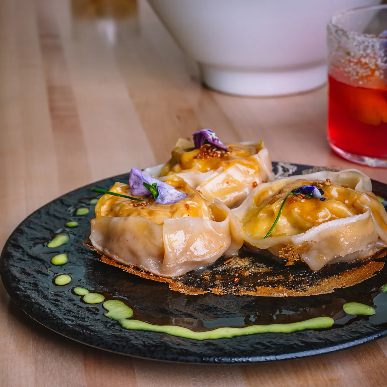 Steam rising from dumplings on a dark plate