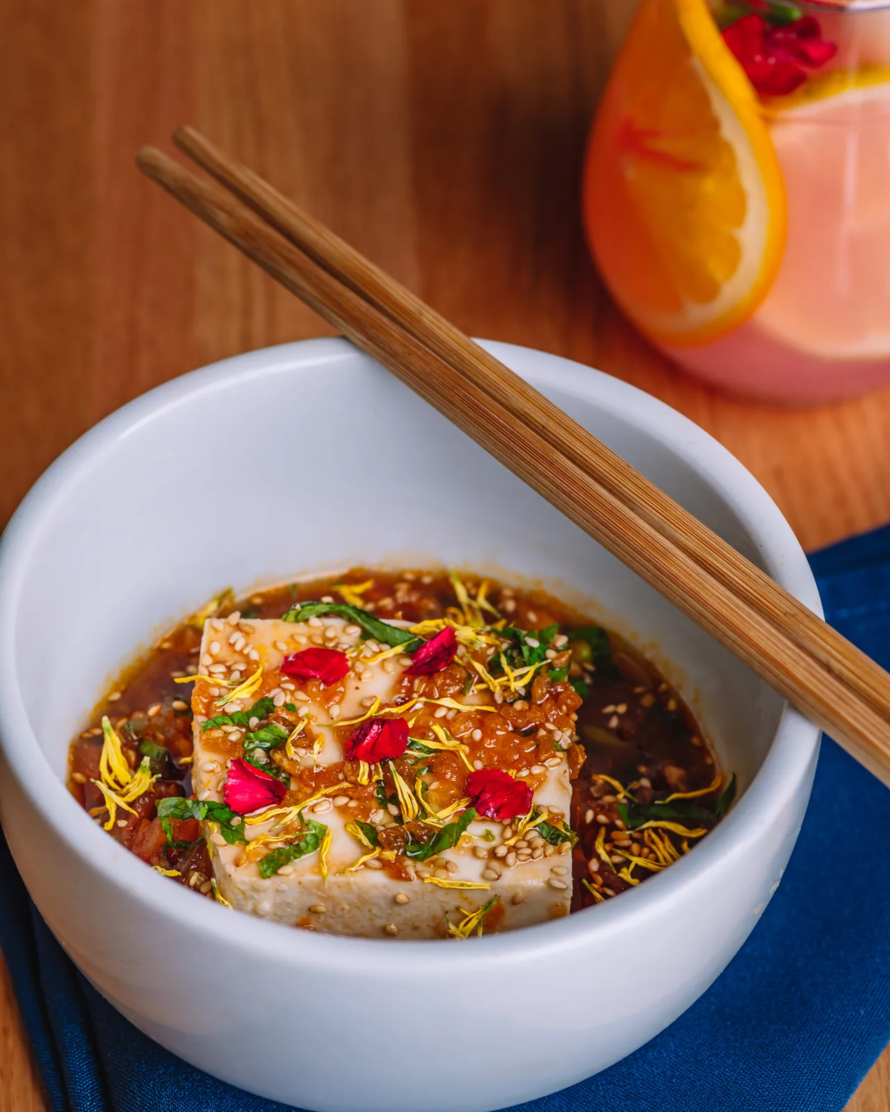 A small bowl topped with red chili and finely chopped herbs
