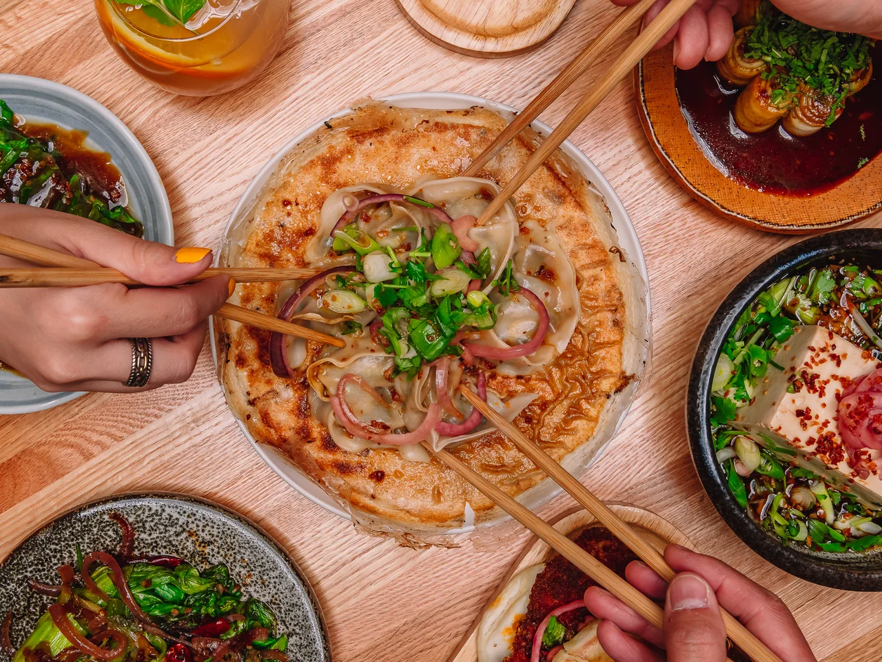 An overhead view of dumplings arranged on a plate with chopsticks