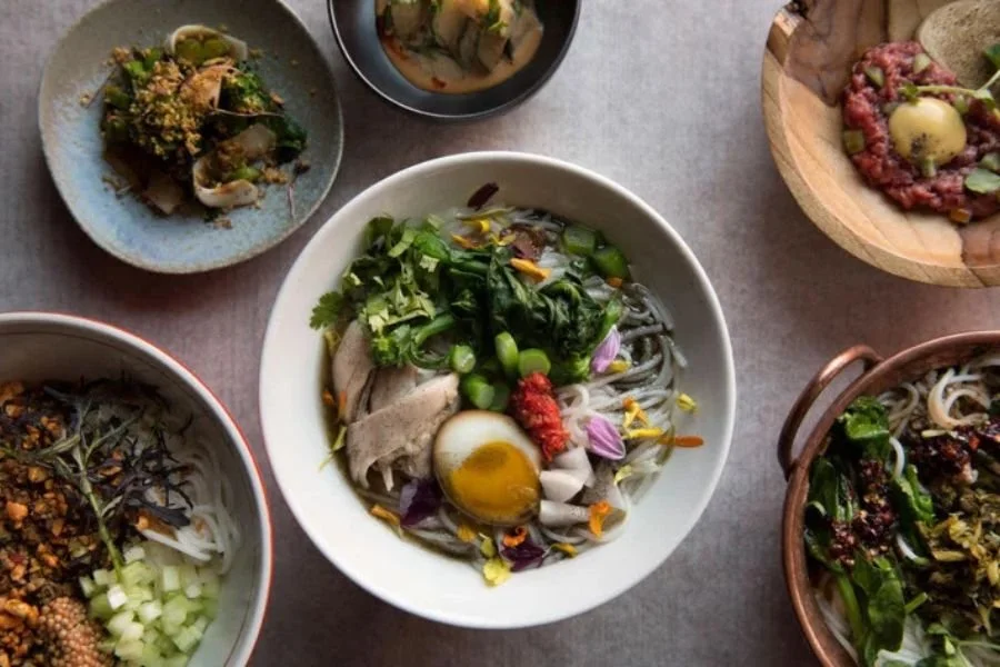 A table set with several bowls of mixian and small plates