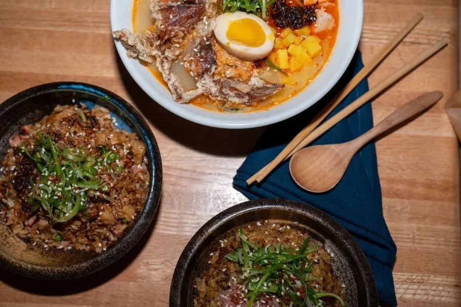 Overhead view of prepared noodle bowls on a wooden table