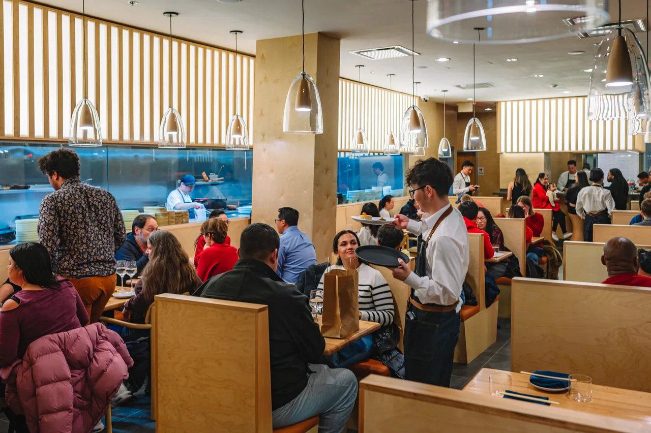 Guests and staff in the Pentagon City dining room beside the open kitchen