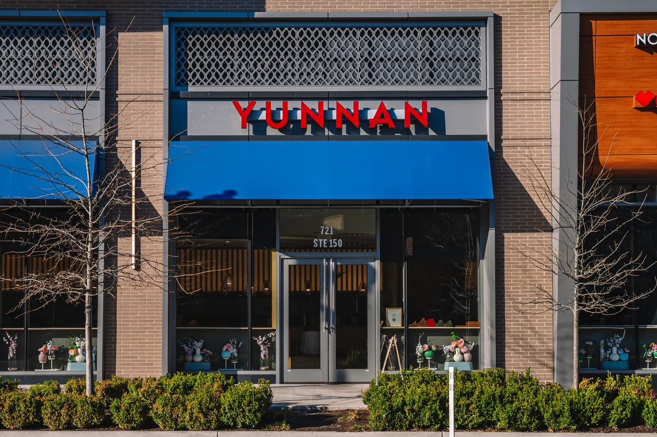 Yunnan storefront with red lettering, blue awning, and the entrance marked 721 Suite 150